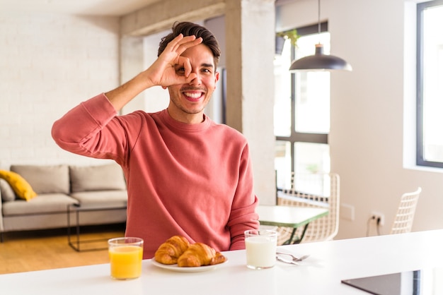 Junge Mischlinge, die morgens in einer Küche frühstücken, sind aufgeregt, die Geste im Auge zu behalten.