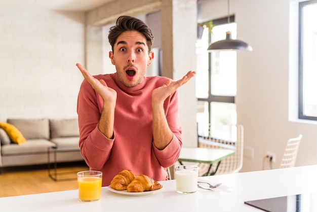 Junge Mischlinge, die morgens in einer Küche frühstücken, überrascht und schockiert.