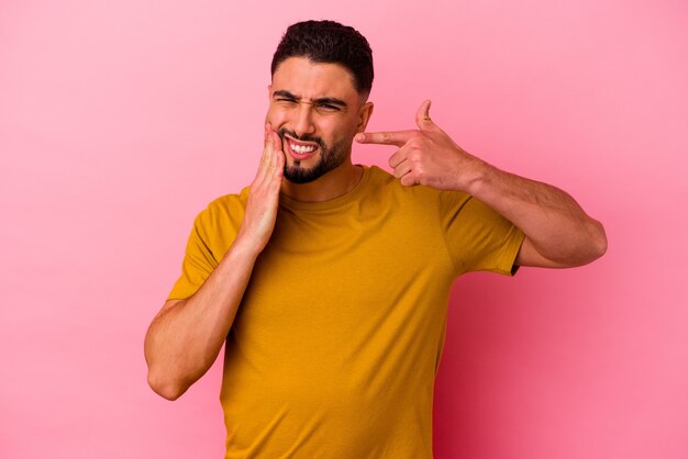 Junge Mischlinge isoliert auf rosa Hintergrund mit starken Zahnschmerzen, molaren Schmerzen.