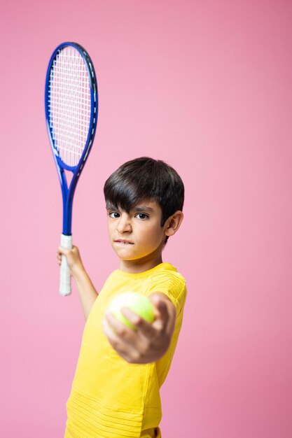 Junge mit aggressivem Gesicht mit Tennisschläger und Ball