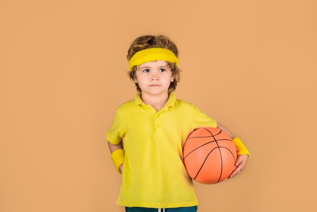 Junge mit Basketballball süßer kleiner Basketballspieler, der Kinder trainiert und kleinen Basketball trainiert