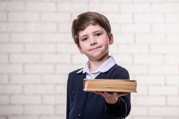 Junge mit einem Buch auf einem weißen Hintergrund