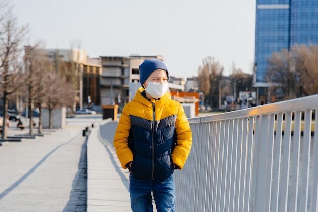 Junge mit Gesichtsmaske, die in den Straßen geht. Coronavirus Prävention