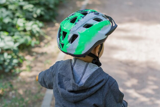 Junge mit Helm auf einem Fahrrad im Park