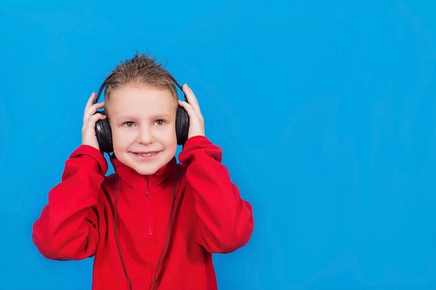 Junge mit Kopfhörern auf einer blauen Oberfläche