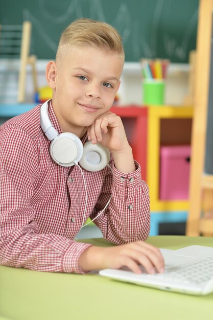 Junge mit Kopfhörern mit Laptop