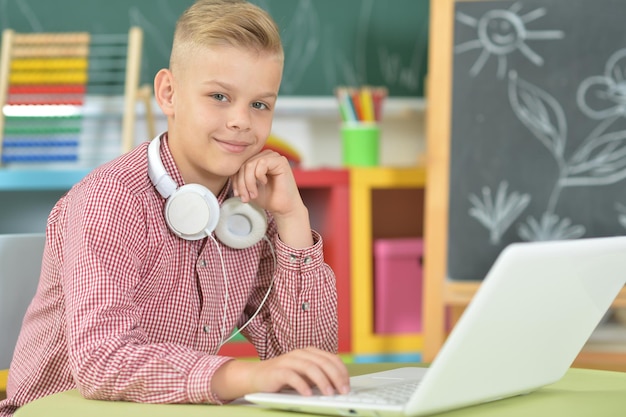 Junge mit Kopfhörern mit Laptop