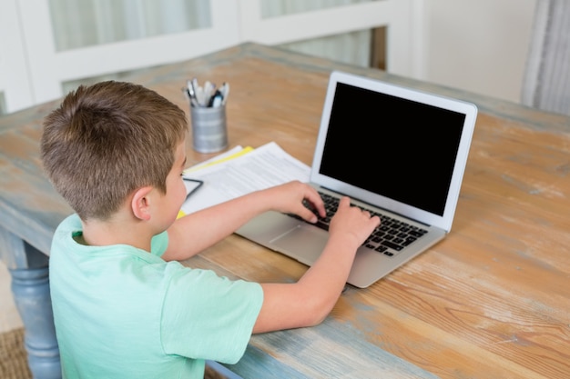 Junge mit Laptop am Schreibtisch