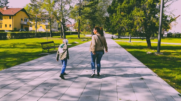 Foto junge mit mutter auf dem fußweg