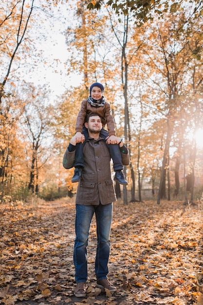 Junge mit Papa im Herbstwald mit orangefarbenen Blättern