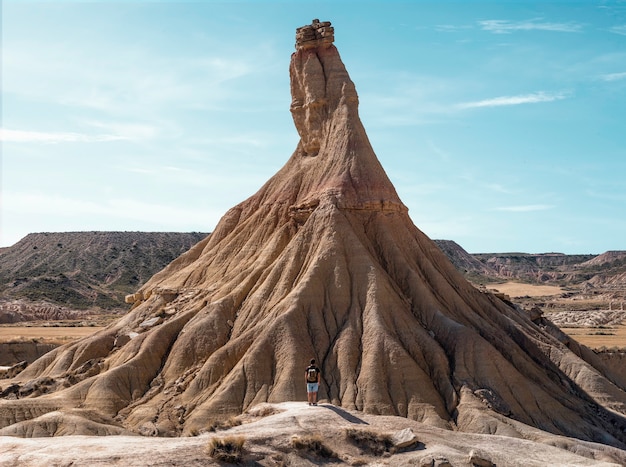 Junge mit Rucksack und kurzen Jeans, die in der Wüstenlandschaft von Bardenas Reales Navarra reisen