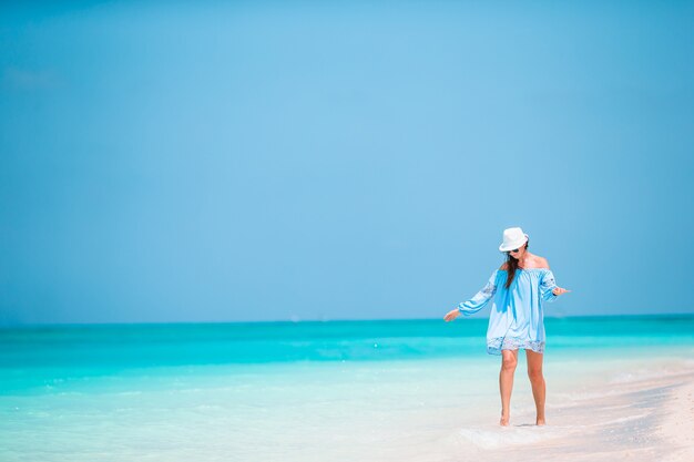 Junge Modefrau im grünen Kleid am Strand