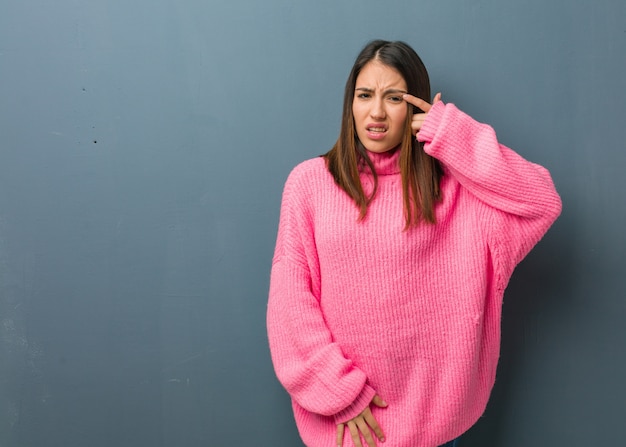 Junge moderne Frau, die eine Enttäuschungsgeste mit dem Finger tut