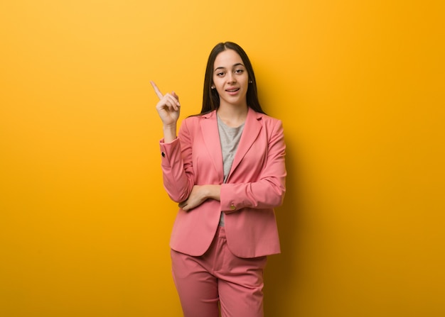 Junge moderne Geschäftsfrau, die auf die Seite mit dem Finger zeigt