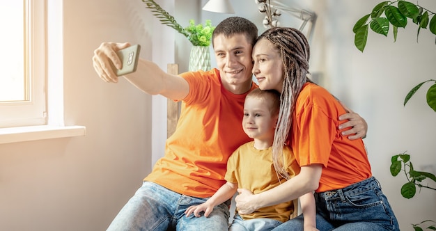 Junge moderne harmonische Familie fotografiert in hellen Kleidern