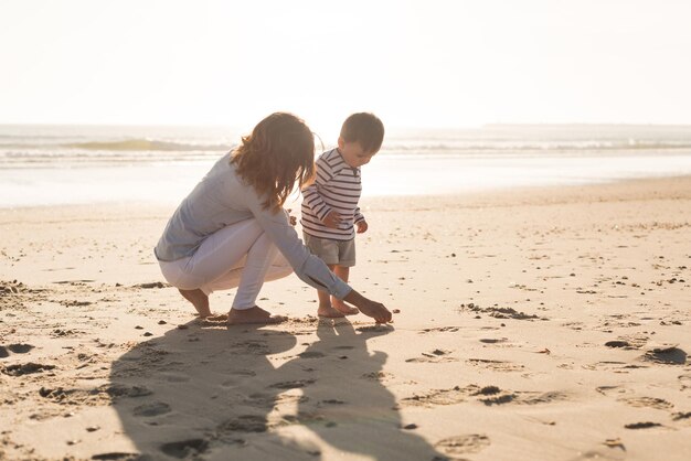 Junge Mutter, die den Strand mit Kleinkind erkundet