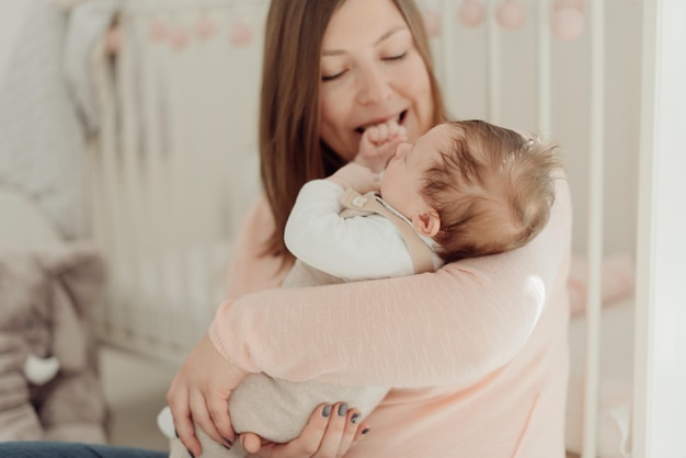 Junge Mutter, die neugeborenes Baby in den Armen hält