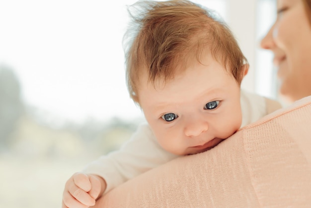 Junge Mutter, die neugeborenes Baby in den Armen hält