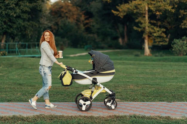 junge Mutter genießt Spaziergang im Park mit Baby