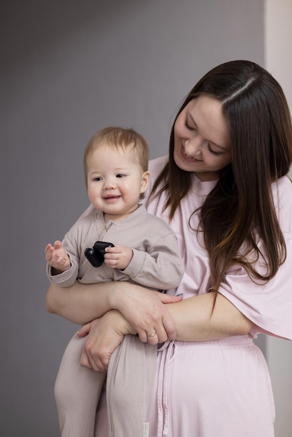 Junge Mutter hält ihr Baby im Arm und lächelt glücklich