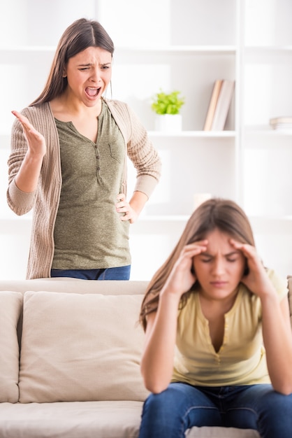 Junge Mutter in einer Diskussion mit ihrer jugendlichen Tochter.