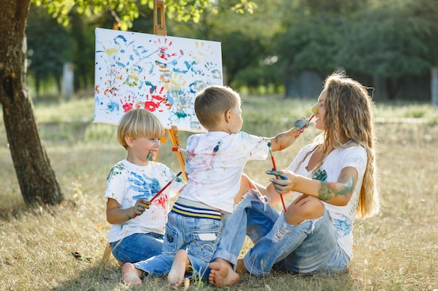 Junge Mutter malt mit ihren Kindern