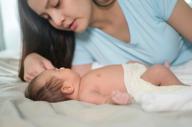 Junge Mutter mit einem niedlichen neugeborenen Baby