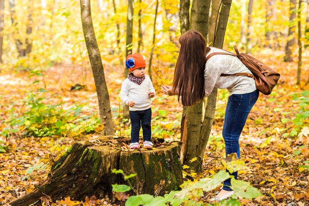 Junge Mutter mit ihrem kleinen Baby im Herbstpark.