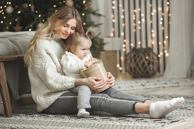 junge Mutter mit ihrem kleinen Baby mit Weihnachtsdekoration