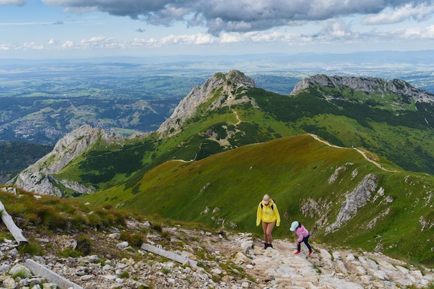 Junge Mutter mit ihrer kleinen Tochter wandert an einem Sommertag in der Tatra