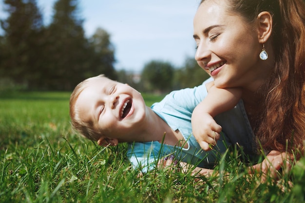 Junge Mutter mit kleinem Sohn hat Spaß beim Spielen im Park