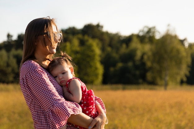 Junge Mutter spielt mit ihrem Baby auf einer Wiese.