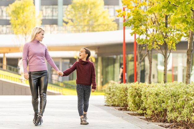 Junge Mutter spielt mit ihrer Tochter im Herbstpark.