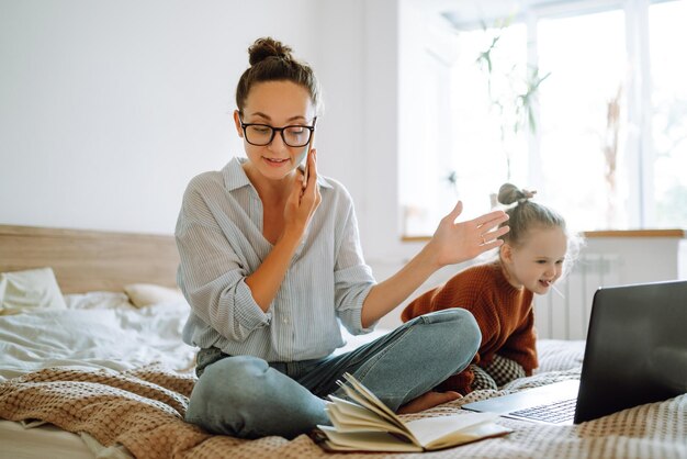 Junge Mutter telefoniert und bespricht Arbeitsprobleme, während sie sich um ihr Kind Covid19 kümmert