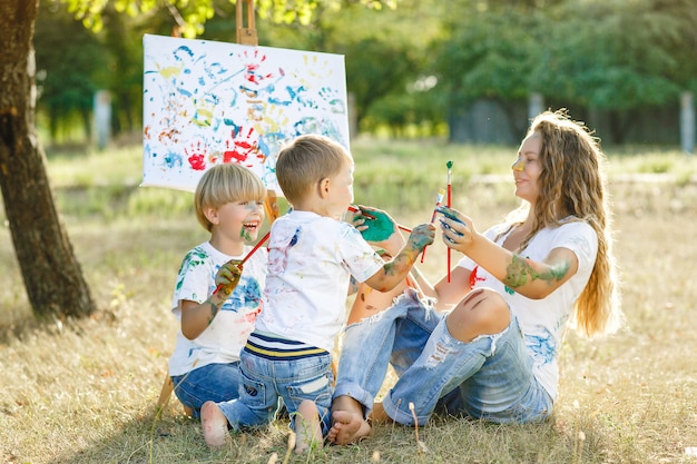 Junge Mutter und ihr Kind, die an einander zeichnen. Glückliche Familie im Freien