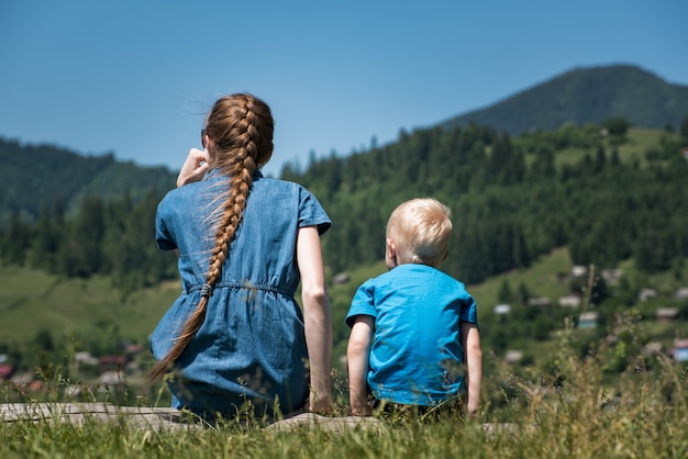 Junge Mutter und kleiner Sohn in der Natur. Landschaft. Rückansicht