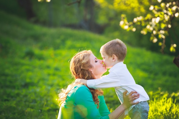 Junge Mutter und Sohn spazieren im Sommerpark