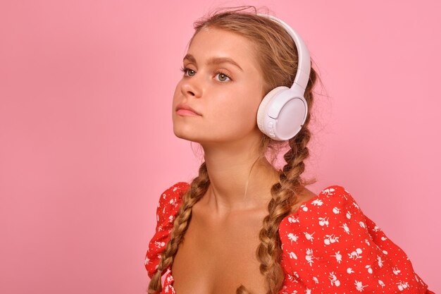 Junge nachdenkliche kaukasische Studentin mit Kopfhörern hört Hörbuch