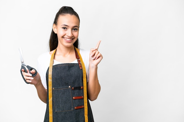 Junge Näherin über isoliertem weißem Hintergrund, die mit dem Finger zur Seite zeigt