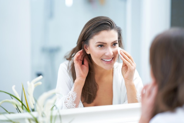 Junge nette Brunettefrau im Badezimmer Foto der hohen Qualität