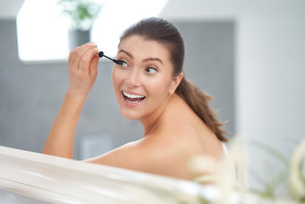 Junge nette Brunettefrau im Badezimmer Foto der hohen Qualität