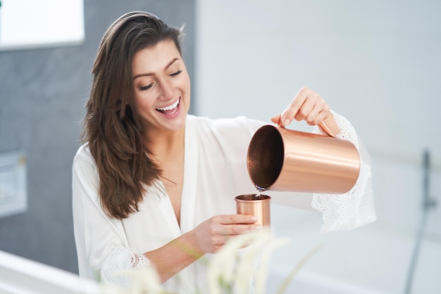 Junge nette Brunettefrau im Badezimmer Foto der hohen Qualität