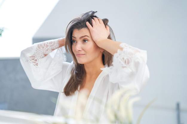 Junge nette Brunettefrau im Badezimmer Foto der hohen Qualität