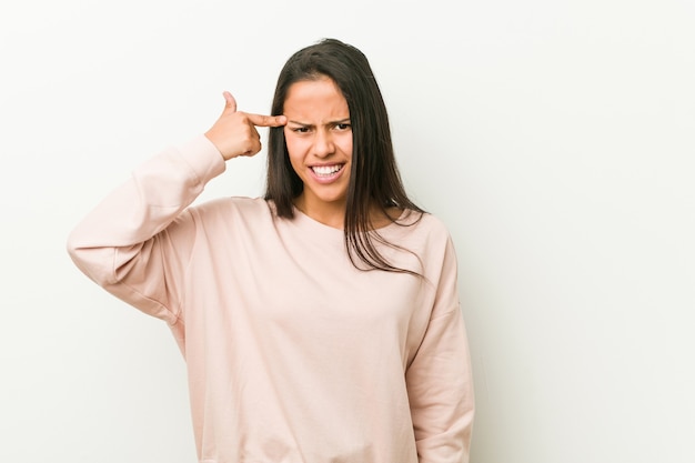 Junge nette hispanische Jugendlichfrau, die eine Enttäuschungsgeste mit dem Zeigefinger zeigt.