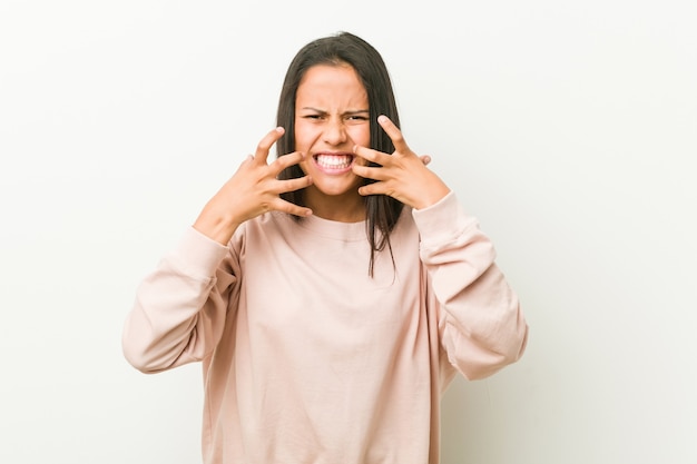 Junge nette hispanische Jugendlichfrau störte das Schreien mit den angespannten Händen.