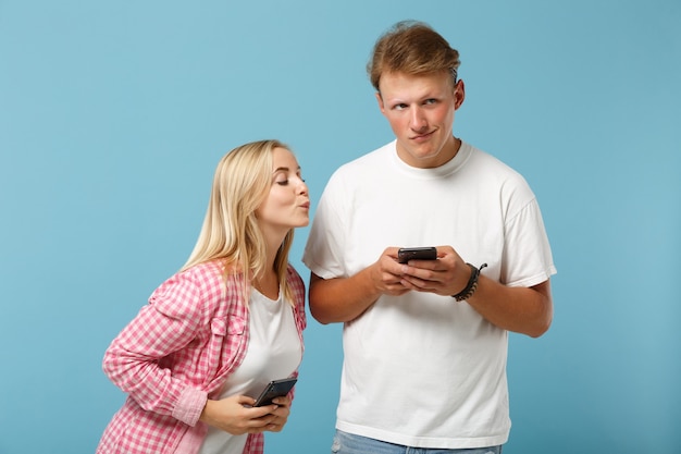 Junge neugierige Paarfreunde Mann und Frau in weißen rosa leeren leeren T-Shirts posieren