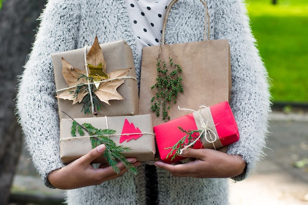 Junge, nicht erkennbare Frau, die mehrere Weihnachtsgeschenke hält