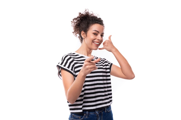 Junge, optimistische, gepflegte, lockige Frau in einem Sommer-T-Shirt lächelt breit