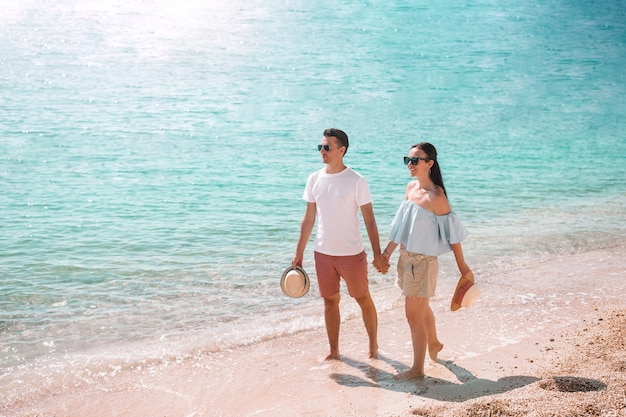 Junge Paare auf weißem Strand an den Sommerferien