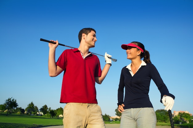 Junge Paare des glücklichen Paars des Golfplatzes verbinden die Unterhaltung